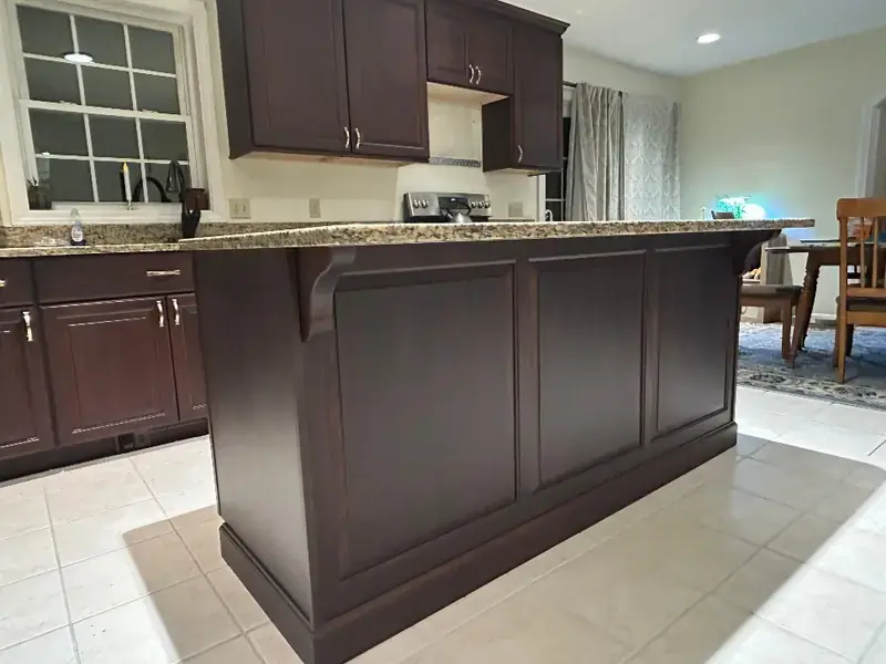 Espresso-finished kitchen island with a granite top