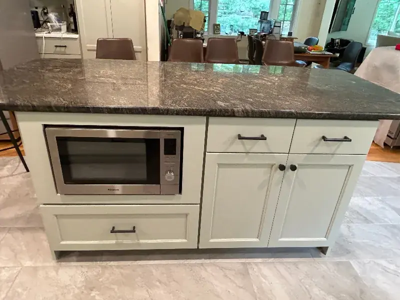 Kitchen island with a built-in microwave and painted cabinets