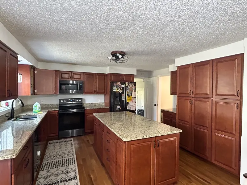 Kitchen before with dated cabinets and island — Homestead Cabinet Design Palmer MA