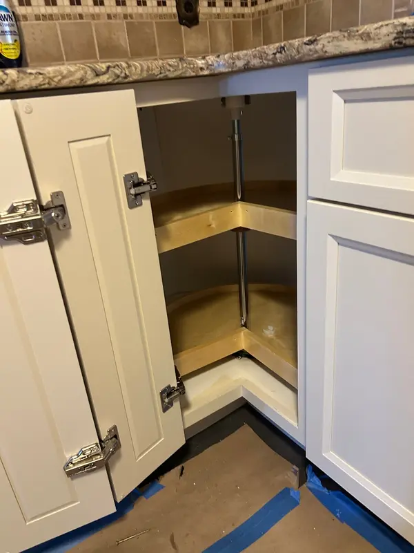 New two-tier wood lazy susan inside a corner cabinet with hinged doors